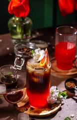 Refreshing iced coffee with blood orange and flower garnish