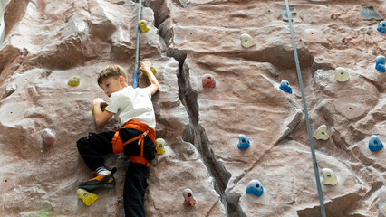 boy at the climbing wall training to climb the wall