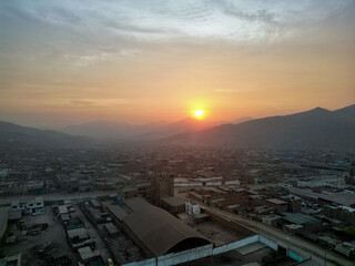 Foggy sunset over the city at the foot of the mountains