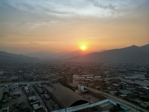 Foggy sunset over the city at the foot of the mountains