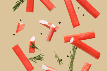 Tasty crab sticks with rosemary and peppercorns flying on green background © Pixel-Shot
