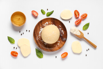 Ingredients for preparing pizza with mozzarella, wooden plate and raw dough on white background