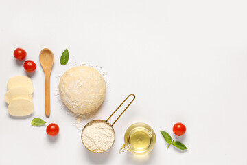 Raw dough, wooden spoon and ingredients for preparing pizza with mozzarella on white background