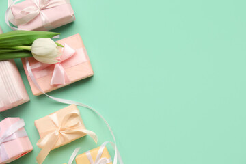Gift boxes with tulip on turquoise background. Happy Women's Day