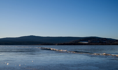 Winter sunny day at a frozen lake with ice floes