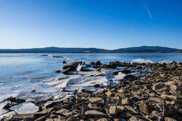 Winter sunny day at a frozen lake with ice floes
