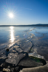 Winter sunny day at a frozen lake with ice floes