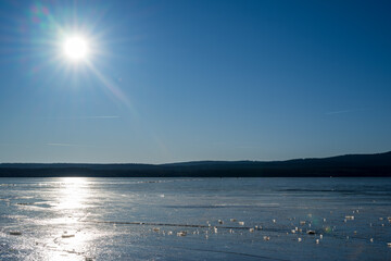 Winter sunny day at a frozen lake with ice floes