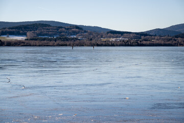 Winter sunny day at a frozen lake with ice floes