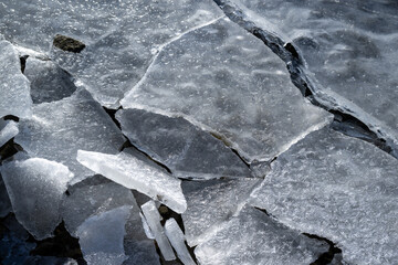 Winter sunny day at a frozen lake with ice floes