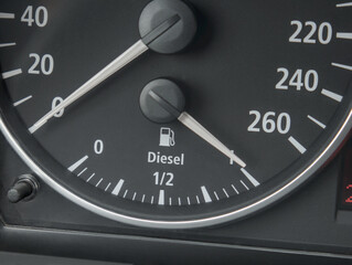 A close-up shot of a car's dashboard gauge showing an overflowing diesel fuel tank