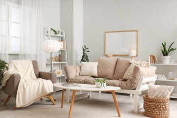 Interior of light living room with armchair, lamp and sofa