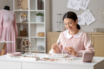 Female jewelry designer examining ring in workshop