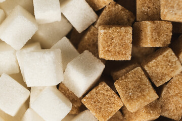 Cubes of unrefined brown demerara sugar and white refined beet sugar.