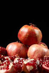 Ripe pomegranates, peeled and whole, the concept of benefits and vitamins in fruit.