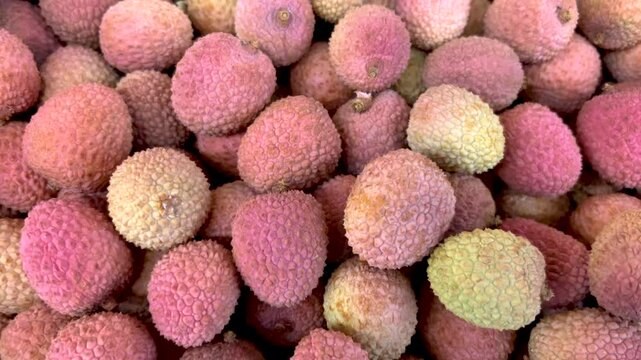 Lychee fruits on greengrocer's counter, tracking shot on Madacascar lychee