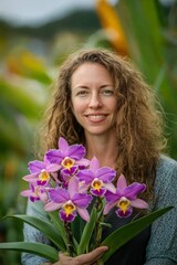 Naklejka premium Smiling woman holds vibrant purple orchids.