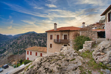Obraz premium Beautiful mountain village at sunset in Greece showcasing traditional architecture and stunning natural scenery