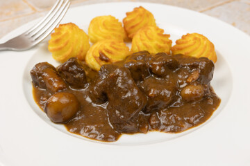 boeuf bourguignon et pommes de terre duchesse, en gros plan, dans une assiette