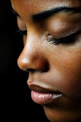 Close-up, dark-skinned face, eyes closed, pensive mood.