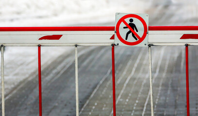 Barrier preventing pedestrian access on a snowy road amidst winter conditions