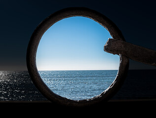 Circular frame made of iron from an anchor in front of the blue sea view and sky