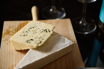 Selection of Fresh Cheese on Wooden Board with Wine Glasses