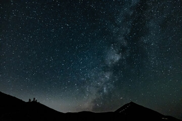 Obraz premium Milky Way over Teide with hikers ascending the volcano 