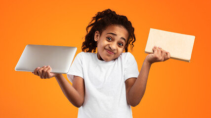Hard Choice. Portrait of uncertain African American girl holding digital tablet and paper book,...