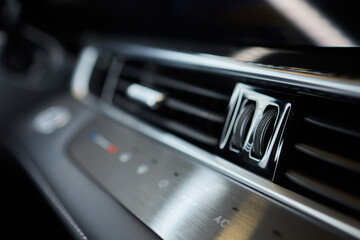 Closeup of car dashboard air vents near gear shift