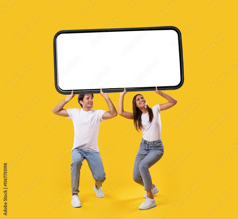 Aufkleber millennial couple holding huge heavy smartphone with white empty screen on yellow orange studio back