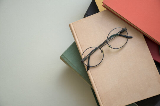 reading glasses on a stack of books - Powered by Adobe