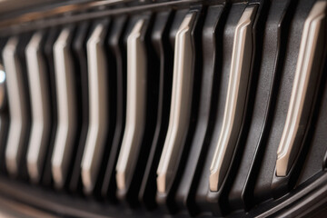 A detailed view of a contemporary car front grille with a stylish design and headlights