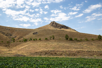 middle eastern landscape hills mountains and trees with blue skies 