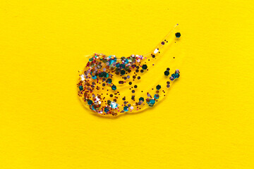 Color glitter stroke on yellow background, closeup