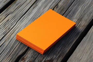 Fototapeta premium Stylish Orange Business Card Mockup on Grunge Wood Surface - Modern Paper Identity Design with Grey and Black Accents