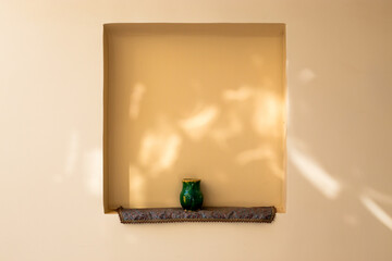 green pottery vase on the a tan wall persian decor middle eastern 