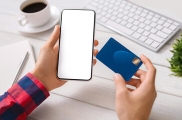 Online payment. Man holding smartphone with blank screen and credit card, making financial transaction