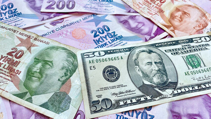 A mix of Turkish Lira banknotes in various denominations alongside a US 50-dollar bill, symbolizing currency exchange, international trade, finance, and global economy.