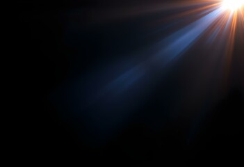Bright sunburst light beam breaking through darkness with blue rays. Natural lens flare effect on black background. Dramatic lighting for dramatic designs with copy space