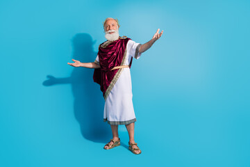 Full body photo of handsome senior male cheerful stretch hands welcome wear ancient greek god king dress isolated on blue color background