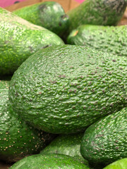 Fresh avocados stacked together in a vibrant marketplace