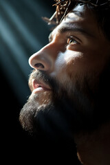 Obraz premium Man with a beard gazes upward, illuminated by beams of light in a dramatic setting