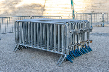Stacked metal security barriers resting on gravel surface