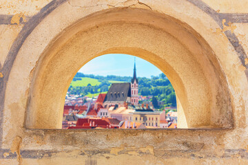 Summer cityscape - view of the loophole of the Cesky Krumlov Castle against the background of the...