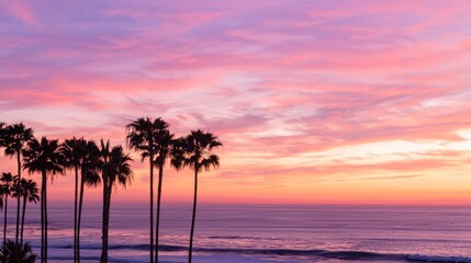 Obraz premium Tropical Paradise: Sunset Silhouette of Palm Trees on Coastline with Gentle Waves