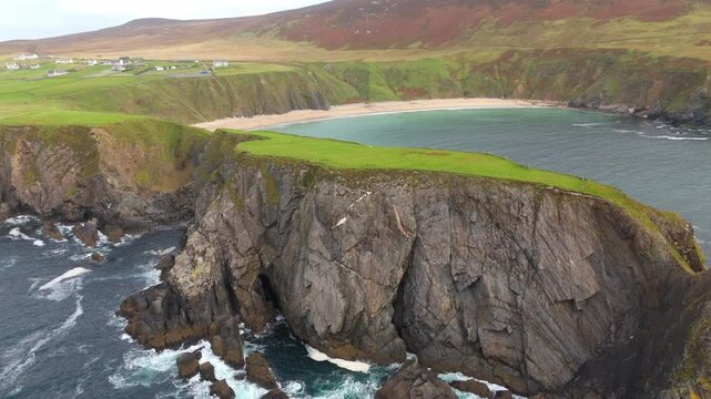 Malin Beg at the west coast of Ireland in Donegal - A breathtakingly stunning view of a rugged coastline featuring rocky cliffs and serene ocean waves softly rolling