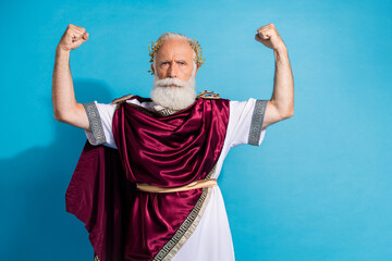 Photo of handsome senior male raise fists strong muscles wear ancient greek god king dress isolated...
