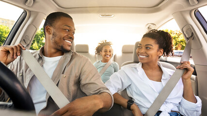 Joyful Black Family Riding New Car Enjoying Summer Road Trip Together. Parents And Little Daughter...