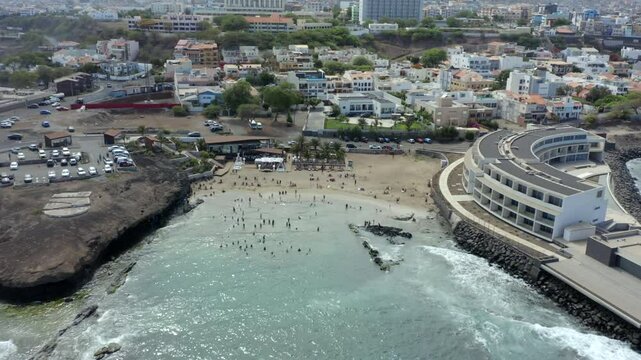 Tourists On Vacation At Prainha Beach In Praia City, Island of Santiago, Cape Verde, Western Africa. Aerial Pullback Shot